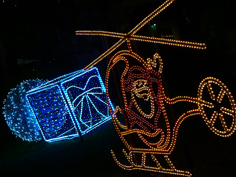 lampki czerwono żółte neonowe w kształcie mikołaja w helikopterze i niebieskie w kształcie prezentu.